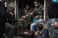 Lực lượng nổi dậy phân phát đạn cho nhau tại quận Karm al-Jabal, thành phố Aleppo ngày 22/10. (Ảnh: AFP/TTXVN)