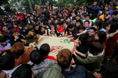 Khi chiếc nồi đất được đập vỡ, hàng ngàn người dân đã xông vào giằng co, giẫm đạp lên nhau để cướp bằng được manh chiếu cói. (Ảnh: Minh Sơn/Vietnam+)