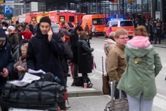 Hành khách được sơ tán ra bên ngoài tòa nhà sân bay ở Hamburg, sau khi phát hiện mùi lạ bất thường trong không khí. (Nguồn: AFP/TTXVN)