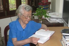 Bà Nhân say sưa đọc hồi ký của những người có công với đất nước. (Ảnh: Thiên Linh/ Vietnam+)