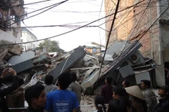 5 tầng nhà đổ sập chặn toàn bộ mặt ngõ rộng tại số 49, Huỳnh Thúc Kháng. (Ảnh: Nguyễn Anh/ Vietnam+)