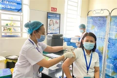 Tiêm vaccine cho những người làm trên tuyến đầu chống dịch. (Ảnh: TTXVN phát)