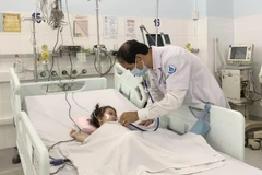 Phó Giáo sư, Tiến sỹ, bác sỹ Phạm Văn Quang, Trưởng Khoa Hồi sức tích cực - chống độc, Bệnh viện Nhi đồng 1 thăm khám cho bệnh nhi. (Ảnh: Đinh Hằng/TTXVN)