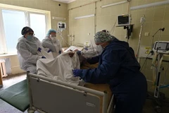 Nhân viên y tế điều trị cho bệnh nhân mắc COVID-19 tại một bệnh viện ở Lviv, Ukraine. (Ảnh: AFP/TTXVN)