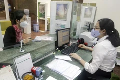 Khách hàng giao dịch tại Hội sở Vietcombank. (Ảnh: Trần Việt/TTXVN)