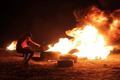 Người biểu tình Palestine đốt cháy lốp xe trong cuộc đụng độ với binh sỹ Israel tại Dải Gaza, ngày 28/8. (Ảnh: THX/TTXVN)