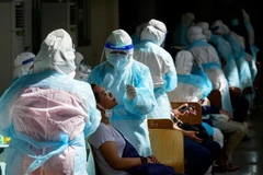 Nhân viên y tế lấy mẫu xét nghiệm COVID-19 tại Bangkok, Thái Lan. (Ảnh: AFP/TTXVN)