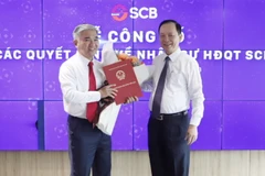 Phó Thống đốc Thường trực NHNN Đào Minh Tú trao quyết định trưng tập, chỉ định ông Phan Đình Điền giữ chức Chủ tịch HĐQT SCB. (Ảnh: PV/Vietnam+)