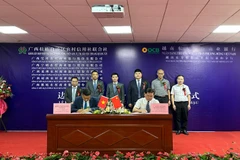 Ông Phạm Bình Hùng, Giám đốc OCB - Chi nhánh Lạng Sơn thực hiện ký kết hợp đồng hợp tác thanh toán biên mậu với các chi nhánh thuộc Khối liên hợp hợp tác xã tín dụng nông thôn khu tự trị dân tộc Choang Quảng Tây. (Ảnh: Vietnam+)