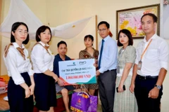 Đại diện Vietcombank Hải Dương và đại diện FWD Việt Nam thăm hỏi, tặng quà và trao biển tượng trưng chi trả quyền lợi bảo hiểm cho anh Phùng Văn Lực. (Ảnh: Vietnam+)