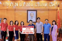 Lãnh đạo Agribank trao số tiền tài trợ cho đại diện trường Hồ Bốn. (Ảnh: Vietnam+)