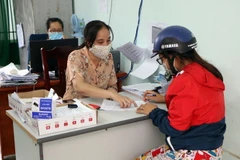 Các địa phương ở thành phố Phan Rang-Tháp Chàm giải quyết chi trả kinh phí cho người thuộc diện thụ hưởng theo Nghị quyết số 68/NQ-CP của Chính phủ. (Ảnh: Công Thử/TTXVN)