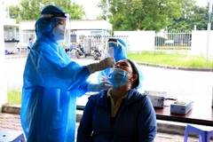 Nhân viên y tế lấy mẫu xét nghiệm COVID-19. (Ảnh: Đinh Văn Nhiều/TTXVN)