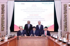 Ông Võ Văn Hoan, Phó Chủ tịch Ủy ban Nhân dân Thành phố Hồ Chí Minh (đứng, phải) và ông Jaya Ratnam, tân Đại sứ Cộng hòa Singapore tại Việt Nam (đứng, trái) chứng kiến lễ ký. (Ảnh: Xuân Khu/TTXVN)