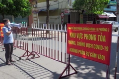 Lực lượng chức năng thông báo cho người trong khu phong tỏa tuân thủ biện pháp phòng dịch COVID-19. (Ảnh: Xuân Triệu/TTXVN)
