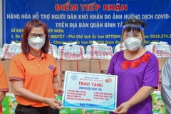 Đại diện chùa Giác Ngộ-Quỹ Đạo Phật Ngày Nay trao tặng vật tư, trang thiết bị y tế, lương thực cho Ủy ban Nhân dân quận Bình Tân. (Ảnh: TTXVN phát)