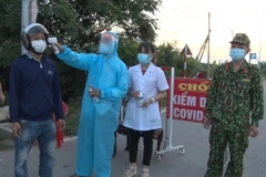 Đo thân nhiệt cho người dân. (Ảnh: Đinh Tuấn/TTXVN)