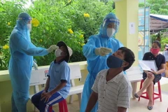 Người dân đến nhận tiền hỗ trợ tại xã Bình Kiến được test nhanh SARS-CoV-2. (Ảnh: Xuân Triệu/TTXVN)