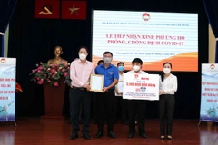 Lãnh đạo Ủy ban Mặt trận Tổ quốc Việt Nam Thành phố tiếp nhận bảng đăng ký ủng hộ tài chính mua Vaccine phòng COVID-19 từ đại diện các tổ chức, doanh nghiệp Thành phố Hồ Chí Minh. (Ảnh: Xuân Khu/TTXVN)