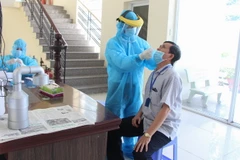 Cán bộ, viên chức các cơ quan trong tỉnh Hậu Giang thực hiện xét nghiệm trong lần xét nghiệm diện rộng đợt 3. (Ảnh: Hồng Thái/TTXVN)