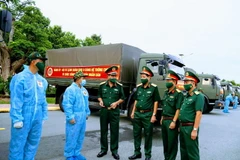Lãnh đạo Bộ Tư lệnh Quân khu 9 với các chiến sĩ lái xe chở hàng tại buổi xuất quân. (Ảnh: TTXVN phát)
