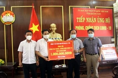 Lễ tiếp nhận 1 tỷ đồng của Công ty cổ phần kính nổi ủng hộ. (Ảnh: Phước Tuệ/TTXVN)