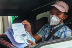Tài xế trình giấy tờ qua các chốt kiểm soát. (Ảnh minh họa: Thanh Liêm/TTXVN)