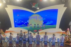 Đại diện Ban Tổ chức trao quà cho các em học sinh có hoàn cảnh khó khăn. (Nguồn: thainguyen.gov)