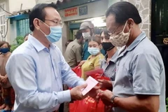 Lãnh đạo quận 8 đến hỗ trợ những hộ dân bị ảnh hưởng. (Ảnh: Hồng Giang/TTXVN)