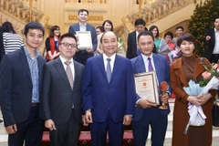 Thủ tướng Nguyễn Xuân Phúc với Phó Tổng giám đốc TTXVN Lê Quốc Minh và các tác giả đạt giải B (thể loại ảnh) thuộc Ban Biên tập Ảnh TTXVN tại lễ trao Giải Búa liềm vàng năm 2019. (Ảnh: Minh Quyết/TTXVN)