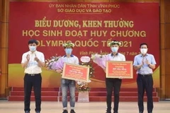 Phó Chủ tịch UBND tỉnh Vĩnh Phúc Vũ Việt Văn trao thưởng cho 2 học sinh đoạt huy chương Olympic quốc tế năm 2021. (Ảnh: Nguyễn Thảo/TTXVN)