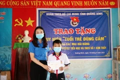 Em Mai Hải Đăng được trao tặng Huy hiệu “Tuổi trẻ dũng cảm” của Trung ương Đoàn vì hành động dũng cảm cứu người đuối nước. (Ảnh: Võ Dung/TTXVN)