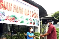 Người dân bị ảnh hưởng do dịch COVID-19 nhận rau miễn phí. (Ảnh: TTXVN phát)