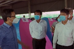 Phó Thủ tướng Vũ Đức Đam thăm, kiểm tra mô hình “3 tại chỗ” tại Công ty TNHH Yazaki EDS Việt Nam, thành phố Dĩ An. (Ảnh: TTXVN phát)