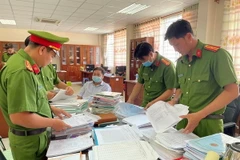 Lực lượng công an khám xét nơi làm việc của các đối tượng, thu giữ nhiều tang vật liên quan đến vụ án. (Ảnh: Công an tỉnh An Giang cung cấp/TTXVN phát)