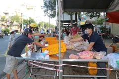 Người mua và người bán giữ khoảng cách, không tiếp xúc trực tiếp để phòng, chống dịch. (Ảnh: Ngọc Thiện/TTXVN)