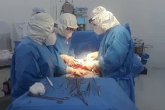 Êkíp y bác sỹ bệnh viện Quân dân y Đồng Tháp thực hiện phẫu thuật cho thai phụ mắc COVID-19 đang mang thai tuần thứ 39. (Ảnh: TTXVN phát)