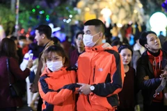 Chỉ một số ít người dân chấp hành đeo khẩu trang phòng, chống dịch đi đón Giáng sinh. (Ảnh: Thành Đạt/TTXVN)