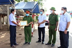 Phó Bí thư Thường trực Huyện ủy Châu Đức, tỉnh Bà Rịa-Vũng Tàu Nguyễn Tấn Bản trao bằng khen cho Thiếu tá Trương Huy Dũng. (Ảnh: TTXVN phát)