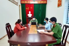 Lực lượng chức năng làm việc đối tượng liên quan đến hành vi cung cấp, chia sẻ thông tin sai sự thật, xuyên tạc, xúc phạm uy tín của cơ quan, tổ chức. (Ảnh: Cường Quân/TTXVN)