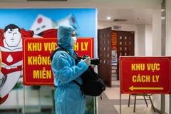 Phóng viên Minh Quyết, Ban Biên tập Ảnh TTXVN, tác nghiệp trong khu cách ly phòng COVID-19. (Ảnh: TTXVN)