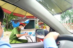 Người dân trở về Vĩnh Phúc khai báo y tế tại chốt kiểm soát dịch COVID-19. (Ảnh: Hoàng Hùng/TTXVN)