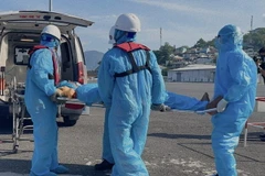 Nhân viên của Trung tâm Phối hợp tìm kiếm, cứu nạn hàng hải Việt Nam khu vực IV tại Khánh Hòa đưa bệnh nhân lên bờ để chuyển bệnh viện điều trị. (Ảnh: TTXVN phát)