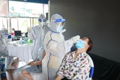 Trung tâm y tế thành phố Đồng Xoài tiến hành lấy mẫu test nhanh SARS-CoV-2 các trường hợp tham gia sự kiện. (Ảnh: Đậu Tất Thành/TTXVN)