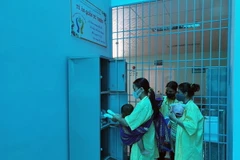 Người nhà bệnh nhân nhận quần, áo tại “Tủ quần áo 0 đồng” của Khoa Nhi ở Bệnh viện Đa khoa tỉnh Kon Tum. (Ảnh: Khoa Chương/TTXVN)