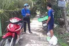 Lực lượng "Shipper áo xanh xứ Dừa" giao hàng đã mua giúp người dân Bến Tre. (Ảnh: Huỳnh Phúc Hậu/TTXVN)