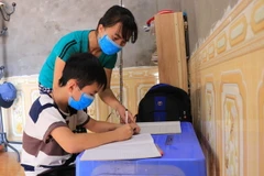 Chị Nguyễn Thị Dung và con trai, thôn Công, xã Mão Điền, huyện Thuận Thành đã khỏi bệnh về với cuộc sống thường ngày. (Ảnh: Thanh Thương/TTXVN)