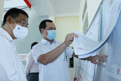 Chủ tịch Tổng Liên đoàn Lao động Việt Nam Nguyễn Đình Khang kiểm tra danh sách cử tri tại phường Tân Phong, thành phố Lai Châu. (Ảnh: Nguyễn Oanh/TTXVN)