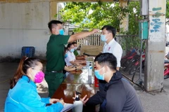 Kiểm tra thân nhiệt và khai báo y tế tại chốt kiểm soát liên ngành phòng, chống dịch COVID-19 ở cảng cá Quy Nhơn, phường Hải Cảng, thành phố Quy Nhơn. (Ảnh: Nguyên Linh/TTXVN)