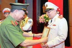 Thừa ủy quyền của Chủ tịch nước, Bộ trưởng Tô Lâm trao Quyết định cho Trung tướng Tô Ân Xô. (Nguồn: cand.com)